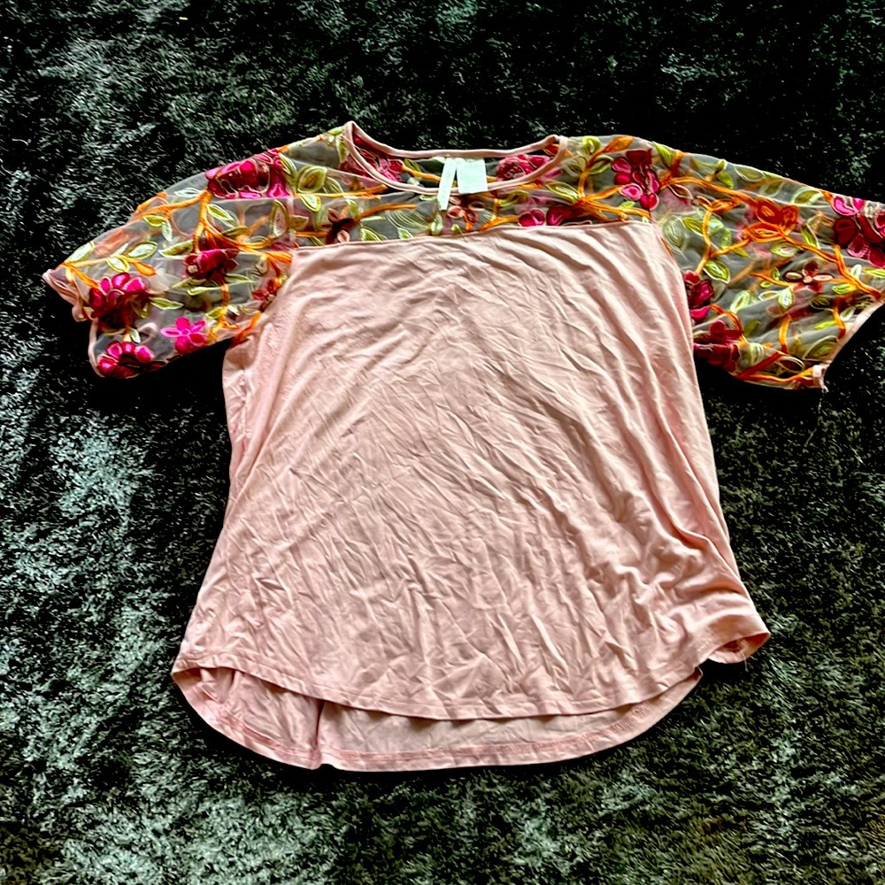 Light pink cotton blouse with floral sleeves.